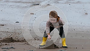 Red headed boy playing on a sandy beach in Northern Ireland Holidays UK