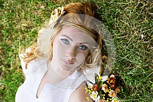 Red-headed woman lying on green grass