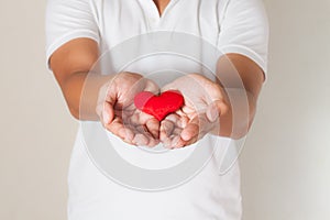 red heart in asian man hands,health- medicine and charity concept