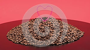 A red heart on a big pile of roasted coffee beans. Composition in red and black tones. The concept of coffee adoration.