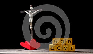 The red heart on black black background including cross beside the heart. The cross is the symbol of Christian religion. God love