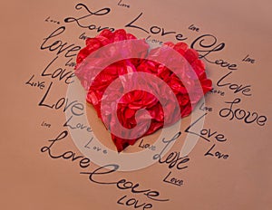 Red heart on a brown background with written words of love