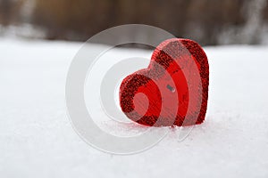 Red heart candle in the snow, a gift for loved ones