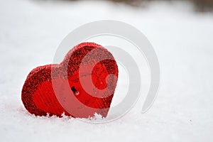 Red heart candle in the snow, a gift for loved ones