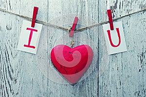 Red heart and card text I LOVE YOU holds on on wooden cloth pegs on a rope