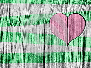 Red heart carved in a wooden board and green strips. Background. Postcard, valentine.