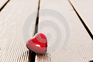 Red heart in crack of wooden plank. Love
