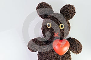 Red heart on cute brown handmade fluffy doll with pitty eyes, healthcare for children or kids, medical learning class