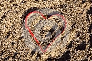 Red heart drawn in the sand