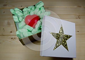 Red heart in gift box with golden star