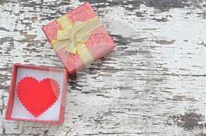 Red heart in gift box on wood background in vintage style