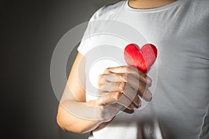 Red heart in girl hand.