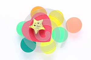 Red heart with gold star on colourful rubber balls