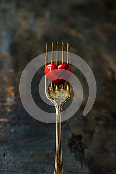 Red heart on golden fork for romantic dining and love symbol in restaurant menu or wedding decor