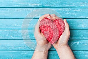 Red heart in hands top view. Healthy, love, donation organ, donor, hope and cardiology concept. Valentines day card.