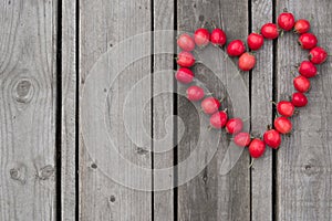 Red heart of hawthorn berries on a wooden background