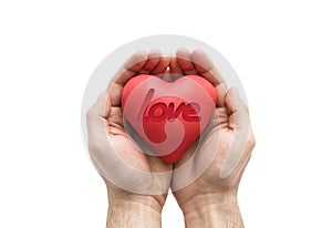 Red heart with imprinted love word in man`s hands.