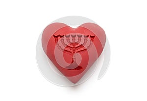 Red heart with imprinted menorah over white background