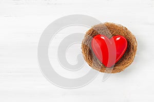Red Heart Inside bird nest on white wood background. Protect  Love with Copy Space