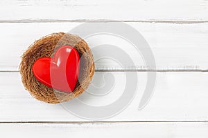 Red Heart Inside bird nest on white wood background. Protect  Love with Copy Space