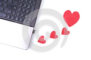 Red heart with laptop on wooden table