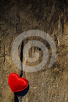 Red heart lies on the crack of old wooden boards