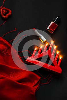 Red heart and lipstick, on a black background, a string of white pearls and a silk handkerchief