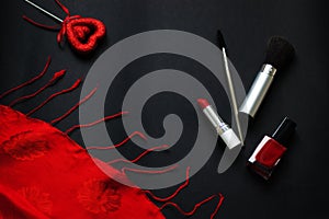 Red heart and lipstick, on a black background, a string of white pearls and a silk handkerchief