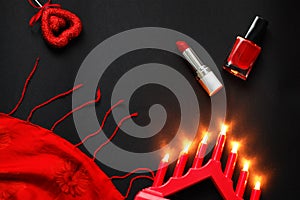 Red heart and lipstick, on a black background, a string of white pearls and a silk handkerchief