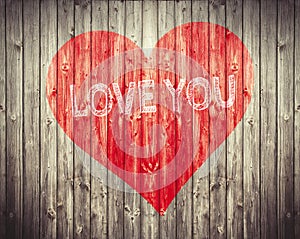 Red Heart and Love You sentence on wooden background. Romantic symbol painted