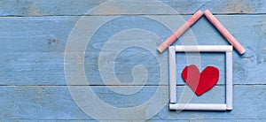 Red heart made of felt on green wooden background.