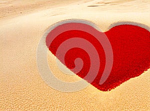 A red heart made out of sand on beach, of sand background. With space for text. Generative AI