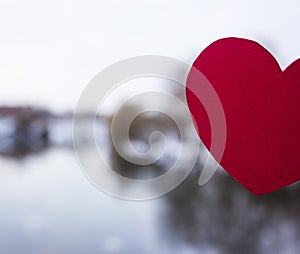 Red heart made of paper on the background of the river