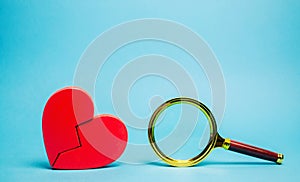 Red heart and a magnifying glass. The concept of finding love and relationships. Find a soul mate. Loneliness. Family psychologist