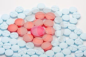 Red heart of medical tablets among blue pills