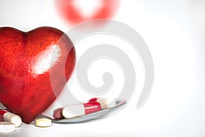Red heart with medication pills isolated on white background, concept drugs,medicine,health,medical care with copy space