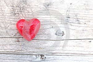 Red heart on natural wooden background as loving heart symbol for wedding greeting card with heart symbol or Valentine`s Day card