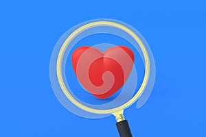 Red heart near magnifier on blue background