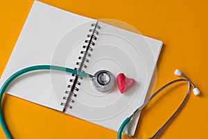 Red heart , notebook and a stethoscope