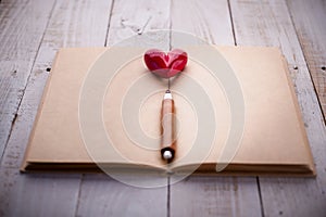 Red heart object with wooden pencil
