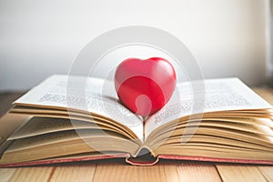 Red heart on open book with copy space in relaxation and cozy mo