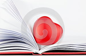 Red heart on the open book with red cover