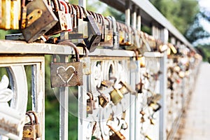Red heart padlock locked on fence. Lock in shape of heart as symbol of eternal love