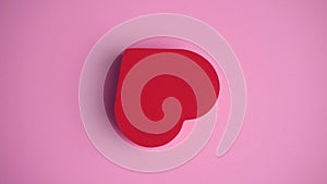 The red heart on the pink background. Valentine's day, love, romance, wedding concept. Minimal art creative video with