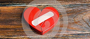 A red heart with a plaster. Renewal of the relationship. Family psychotherapist services. Reconciliation. Saving the family.
