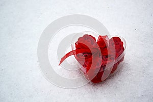 Red heart with roses inside in the snow