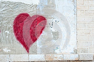 Red heart on a scratched wall