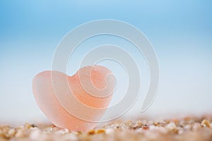 Red heart sea glass on beach sand
