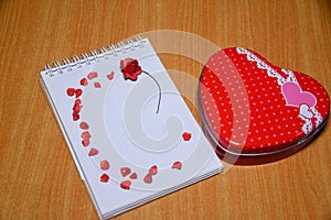 Red Heart shape gift box and red hearts on Blank notepad for copy space on wooden table . Valentines Day background , wedding