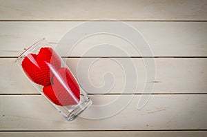 Red heart shape in glass on wooden table, valentine concept